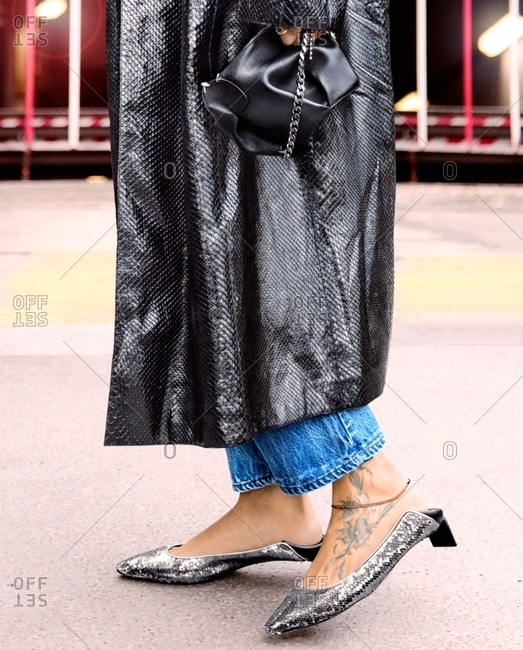 Stylish woman walking down the street wearing long coat and shiny shoes