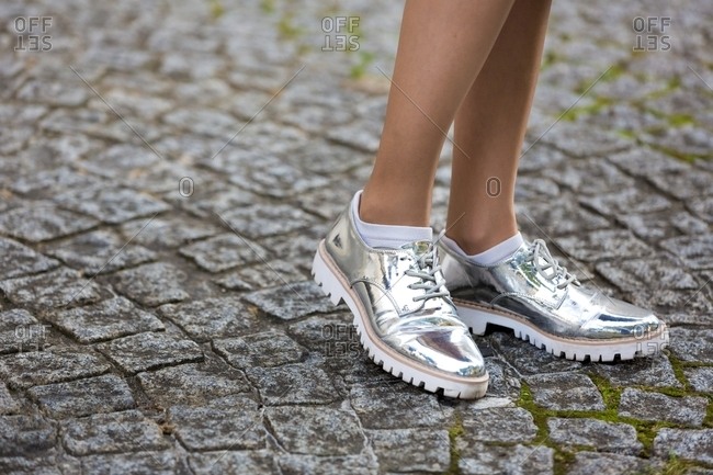 Shiny silver shoes on woman in the streets of Paris