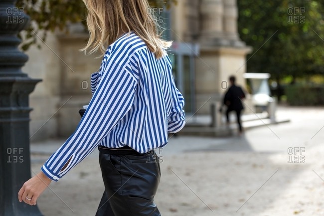 Woman wearing striped blouse and black pants on the streets of Paris
