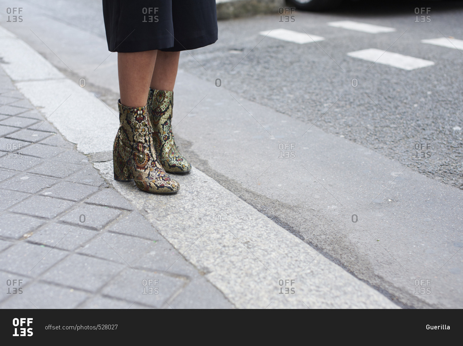 Woman on street in culottes and snakeskin boots, low section