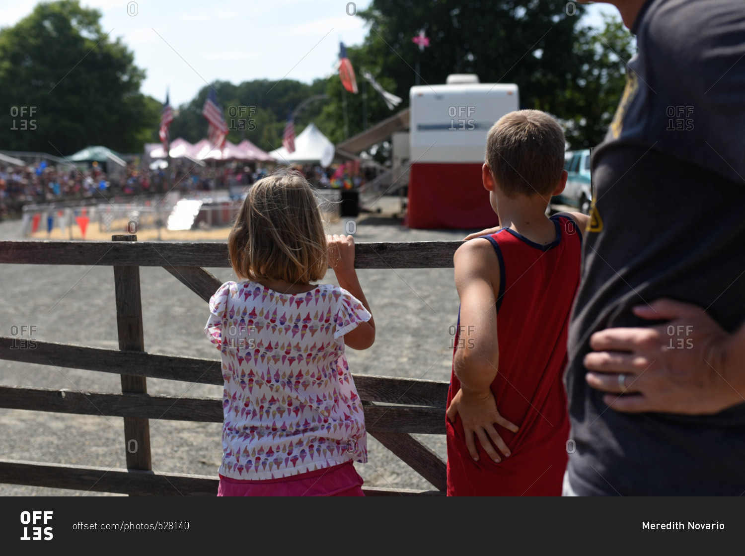 Father and children watching pig races at a fair