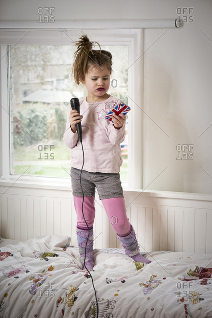 Young girl showing her singing performance in her bedroom