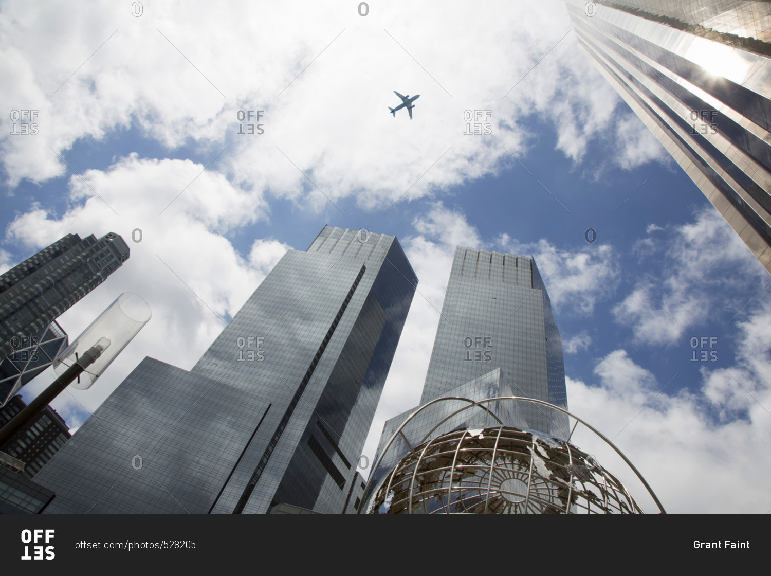 Low angle view of plane flying over the Columbus circle buildings