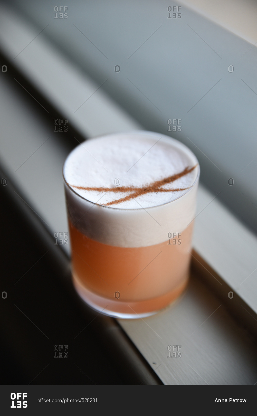 Mixed drink topped with foam and lines of cinnamon