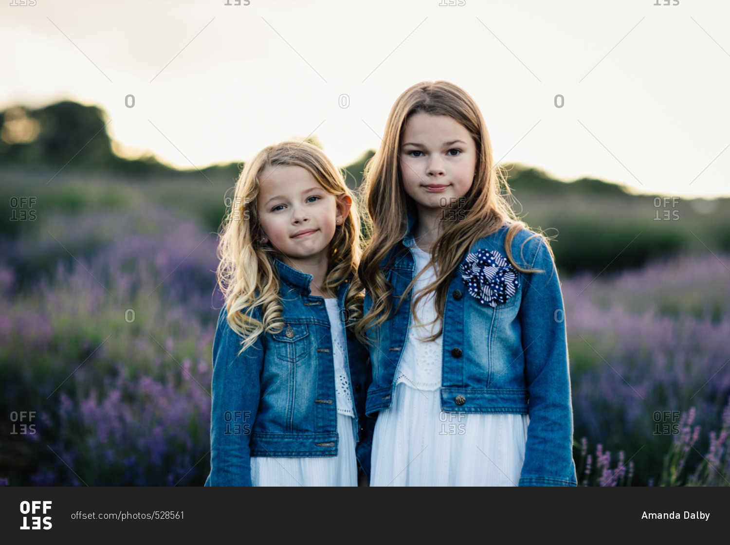 Portrait of two girls standing together in a field of purple lavender flowers