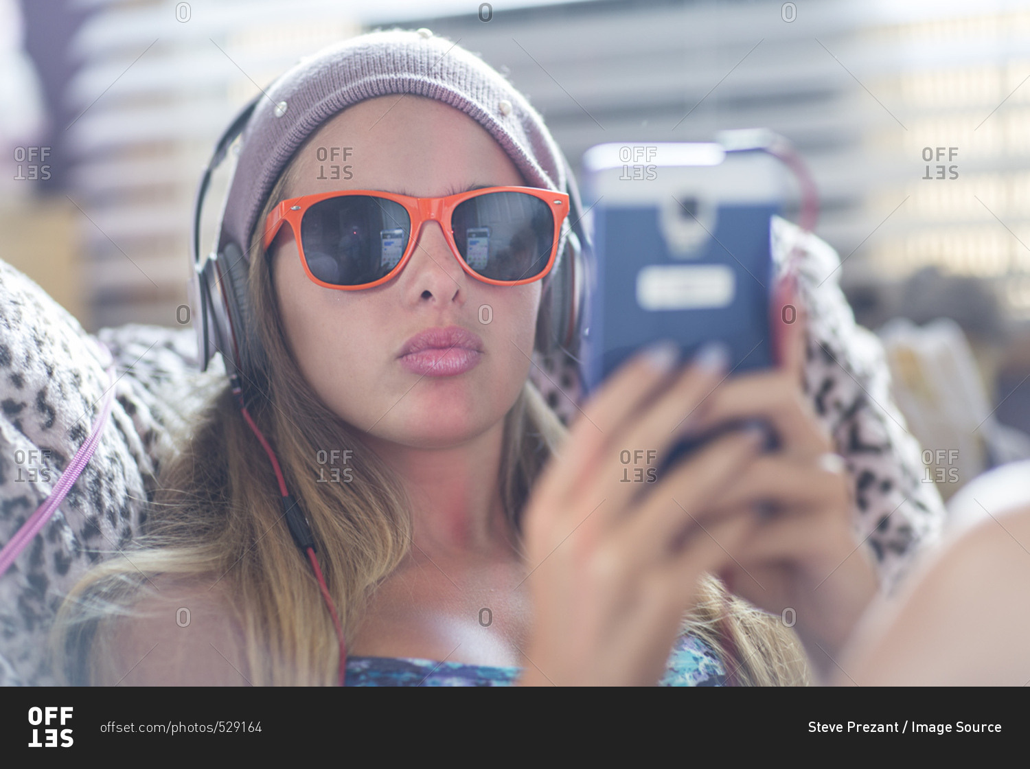 Teenager with sun glasses using smartphone on lazy chair