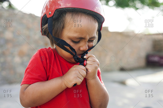 Toddler boy struggles with bike helmet