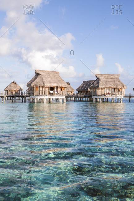 Stilt houses in lagoon of Tikehau against sky