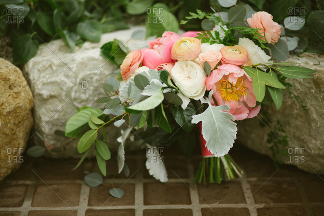 Peony wedding bouquet against stones