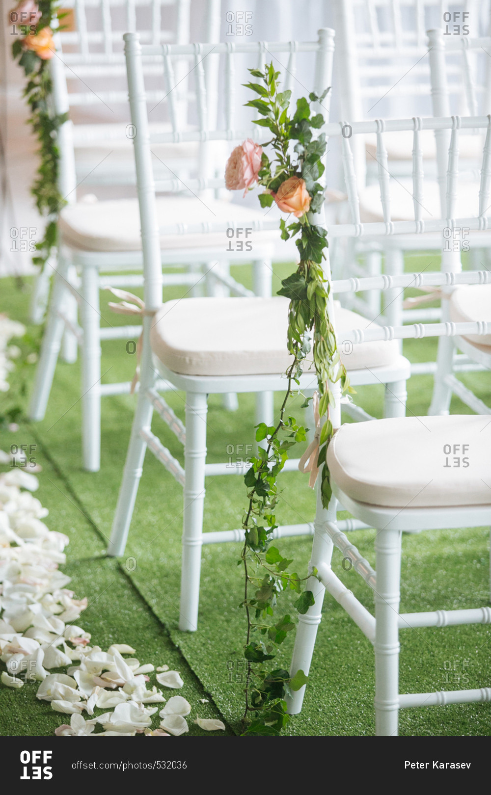 White chairs at a wedding reception decorated with roses