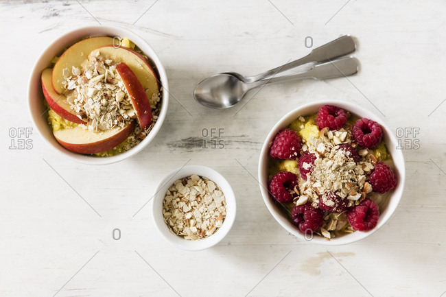 Bowl of porridge with raspberries and bowl of porridge with apples