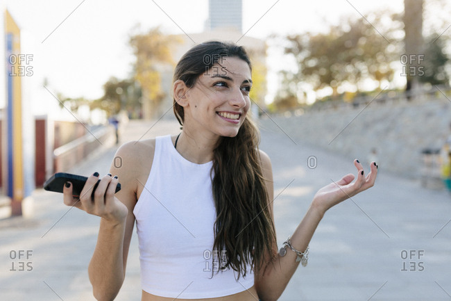 Portrait of grinning young woman with cell phone
