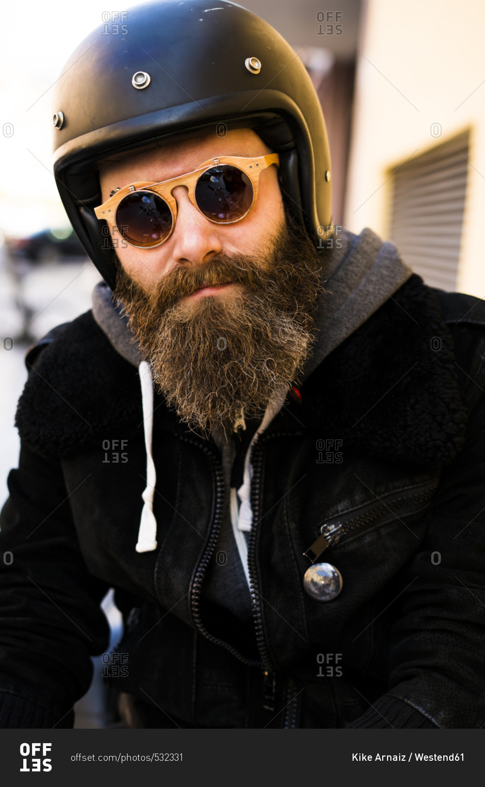 Portrait of bearded biker wearing helmet and sunglasses stock photo - OFFSET