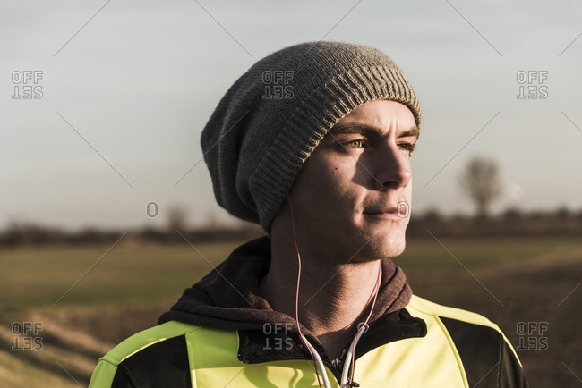 Portrait of athlete wearing wooly hat and earphones
