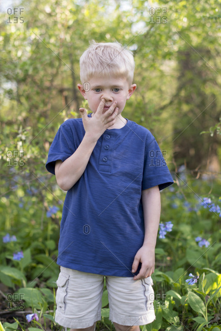 Little blonde boy picking his nose