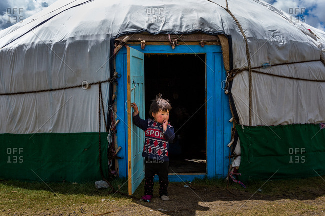 Altai Mountains, Mongolia - July 20, 2016: Little Kazakh boy standing in the doorway of a traditional shelter