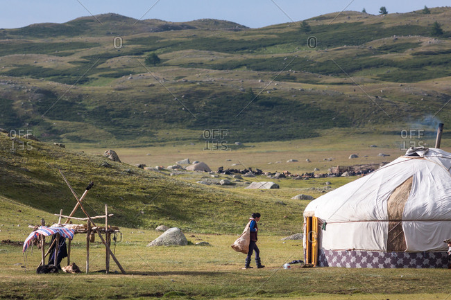Altai Mountains, Mongolia - July 17, 2016: Teenage Kazakh girl by traditional home