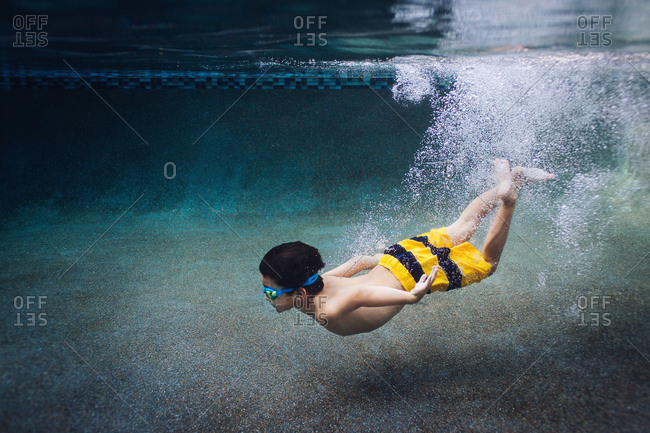 Underwater View Of Boy Diving Into Swimming Pool Stock Photo Offset