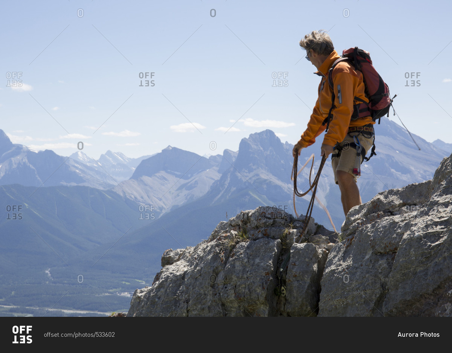 Mountaineer throws rope, mountain range