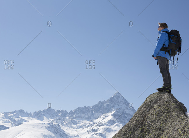 Portrait of mountaineer on summit, above mountains