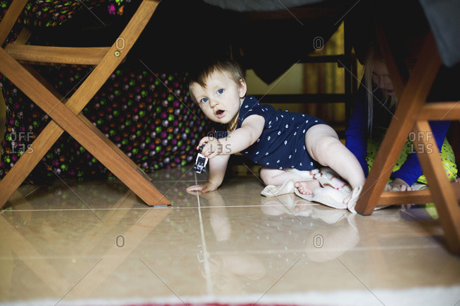 Toddler boy playing in home fort