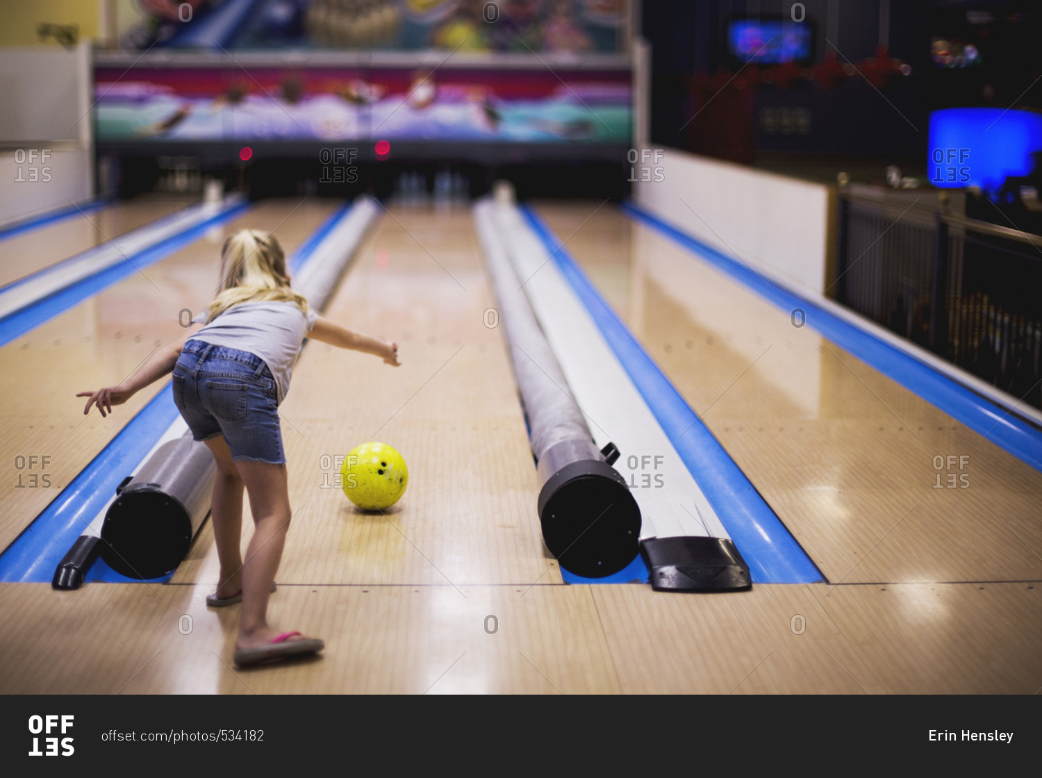 Girl rolling a bowling ball stock photo OFFSET