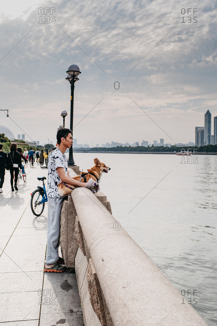 Guangzhou, China - March 26, 2017: Chinese man with a welsh corgi Pembroke dog, in Guangzhou, China.