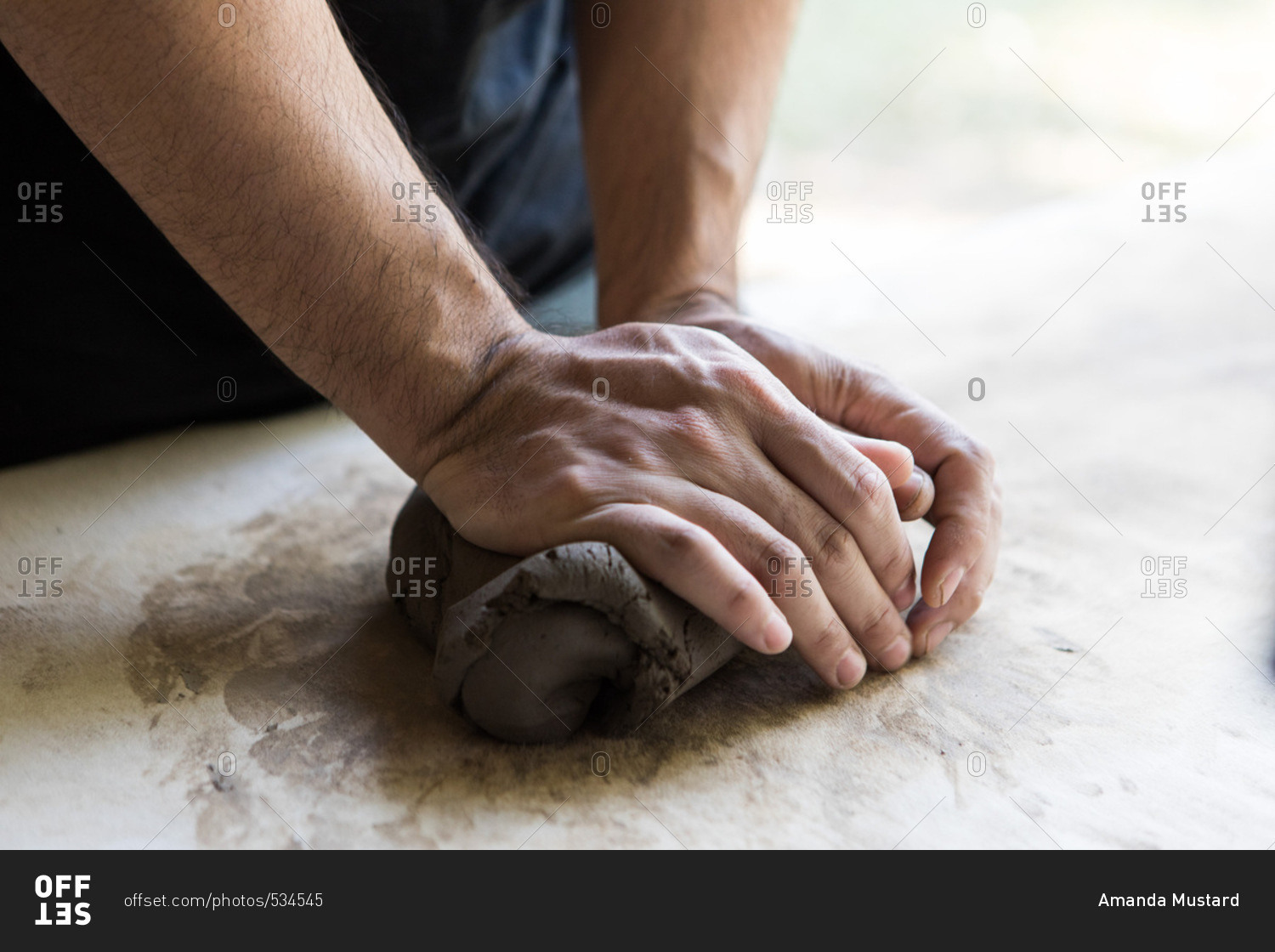 Man molding clay in a pottery and ceramic studio in Chiang Mai, Thailand stock photo OFFSET