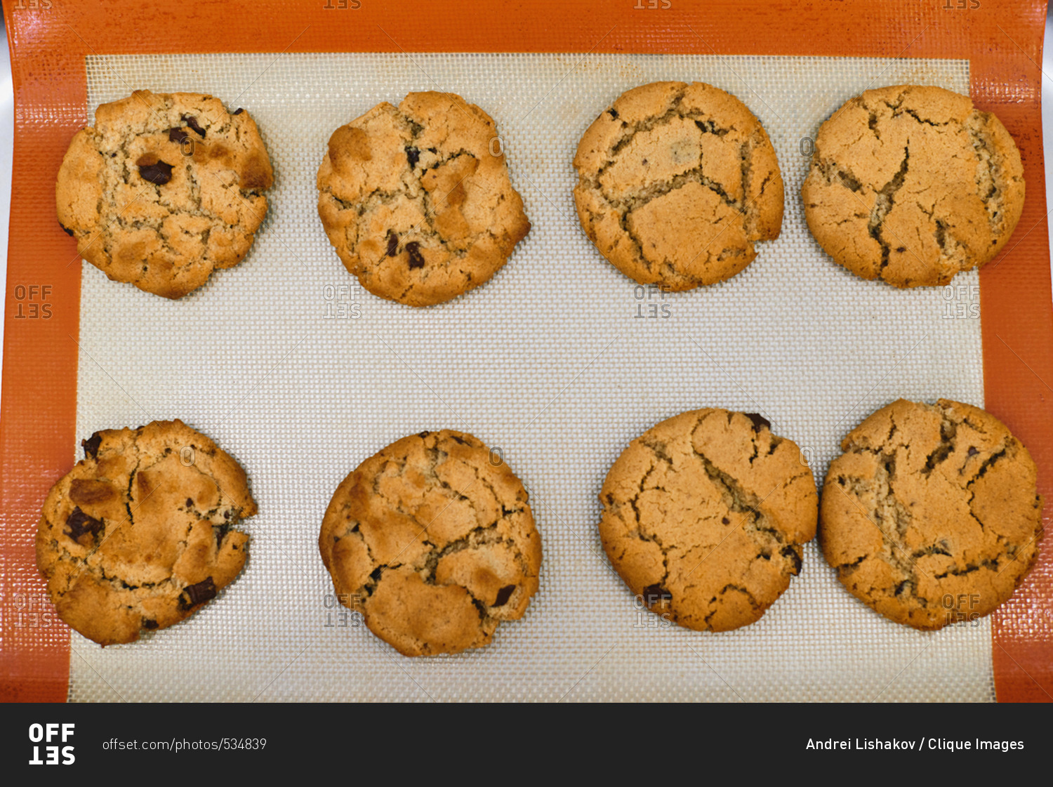 Directly above view of freshly baked crispy chocolate chip cookies lying on silicone baking mat