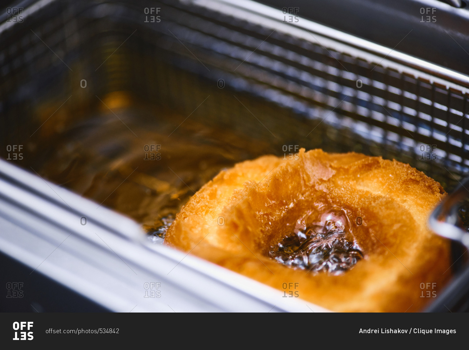 Extreme closeup shot of doughnut being cooked with oil in deep fryer
