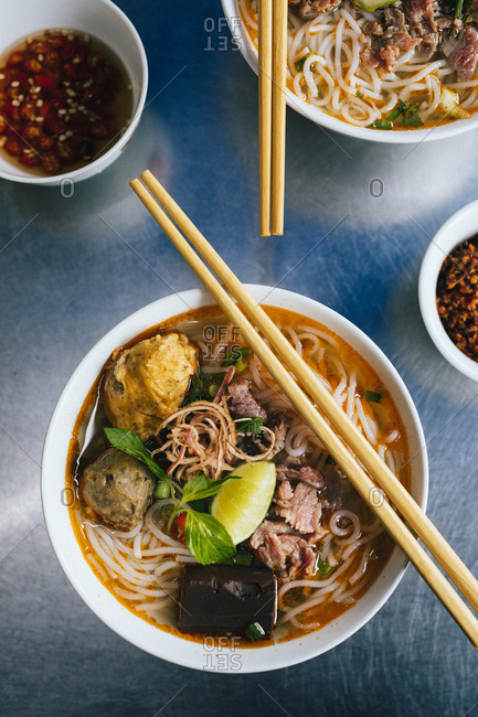A bowl of Bun Bo Hue with beef, crab balls, blood sausage and herbs, a local specialty in Hue, Vietnam