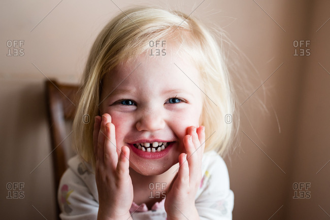 Smiling Toddler Girl With Blonde Hair And Blue Eyes Stock Photo