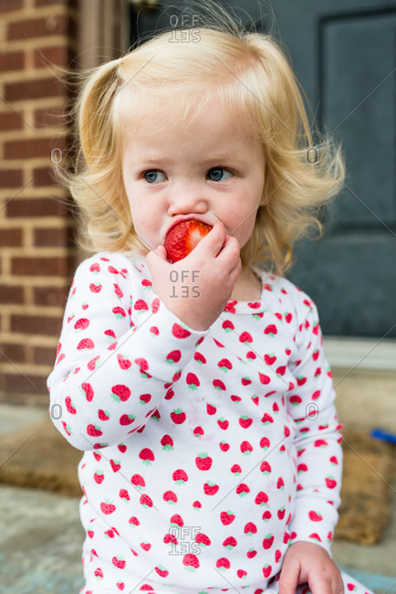 Blonde Toddler Taking Bite Of A Strawberry Stock Photo Offset