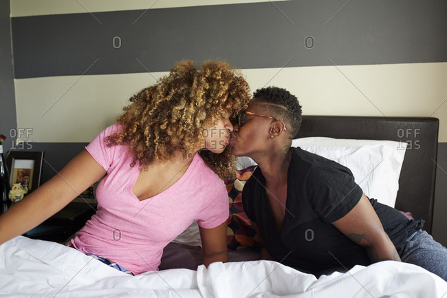 Black women kissing in bed