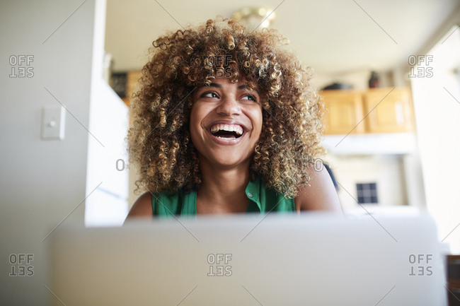 Laughing Black woman using laptop