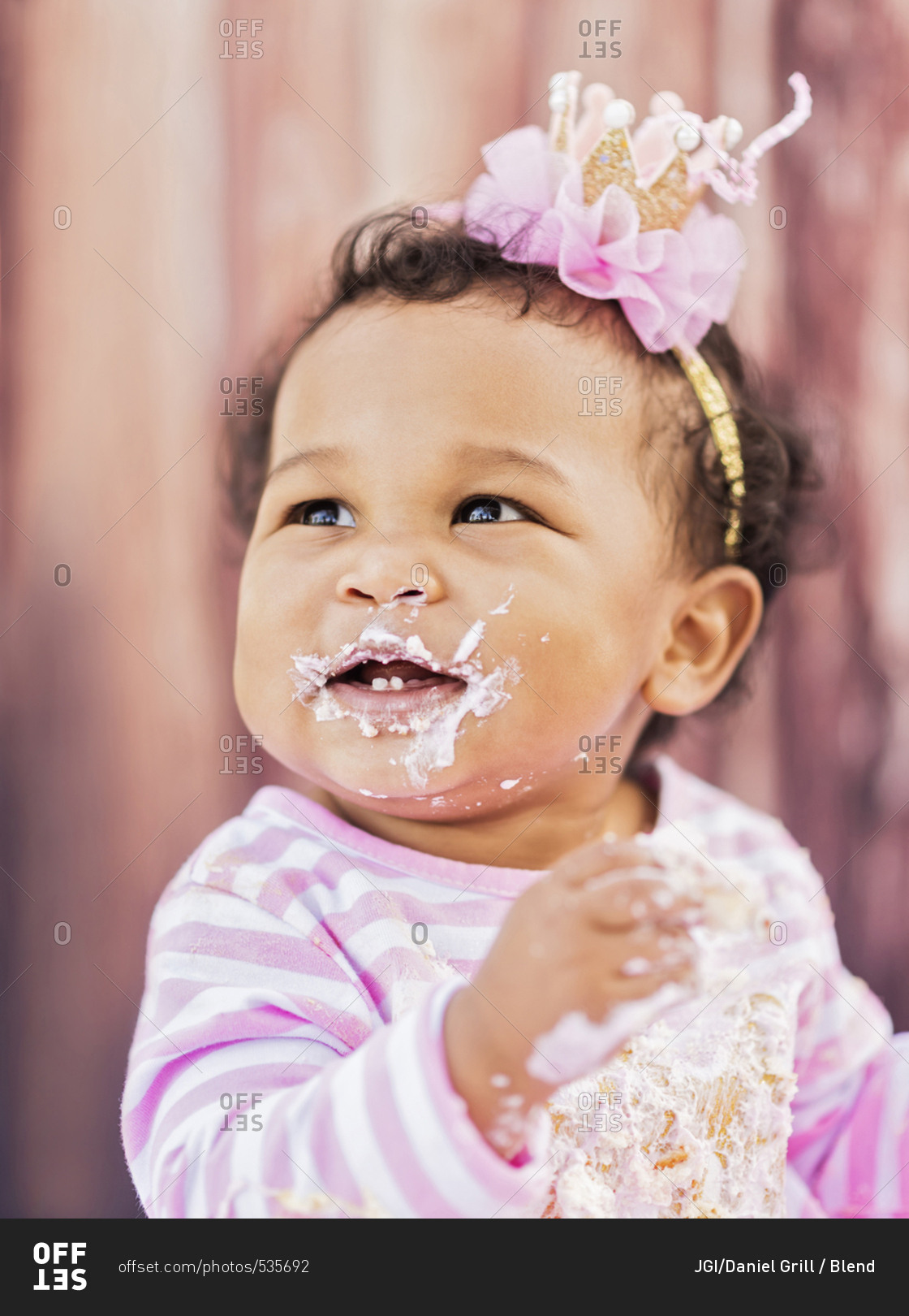 Messy Mixed Race baby eating birthday cake