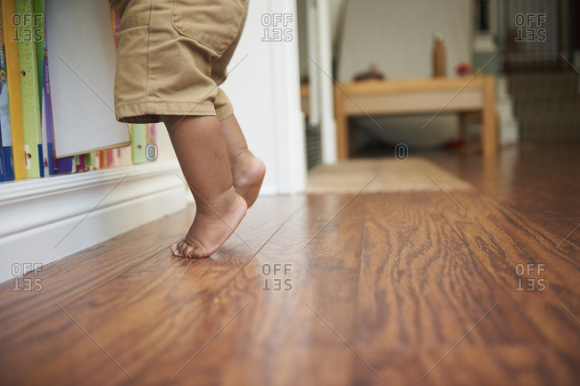 Feet of Black baby boy standing tiptoe