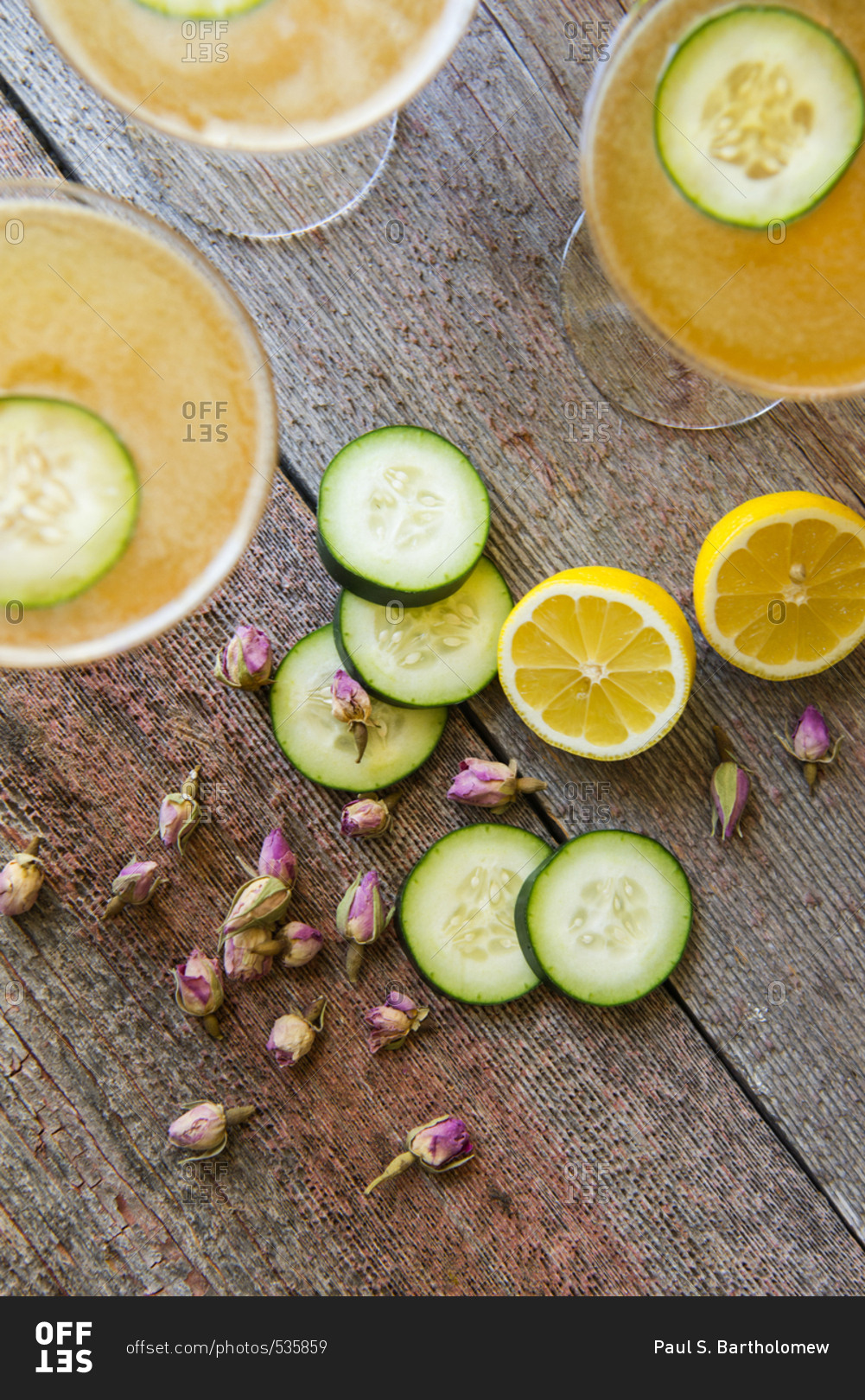 Grapefruit mixed drinks served with cucumber slices, lemon, and flower buds