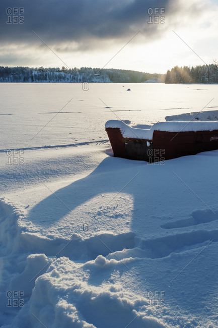 Sweden, Vastra Gotaland, Viaredssjon, Frozen lake with boat in snow