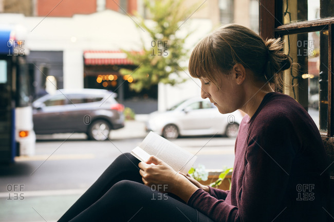 USA, New York, New York City, West Village, Mid adult woman reading