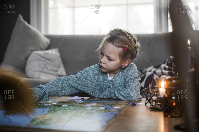 Sweden, Girl playing board game on coffee table