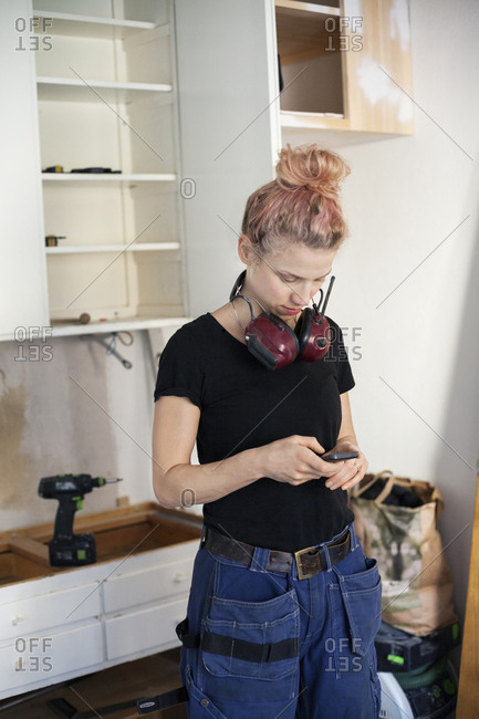 Sweden, Mid adult woman carpenter using phone