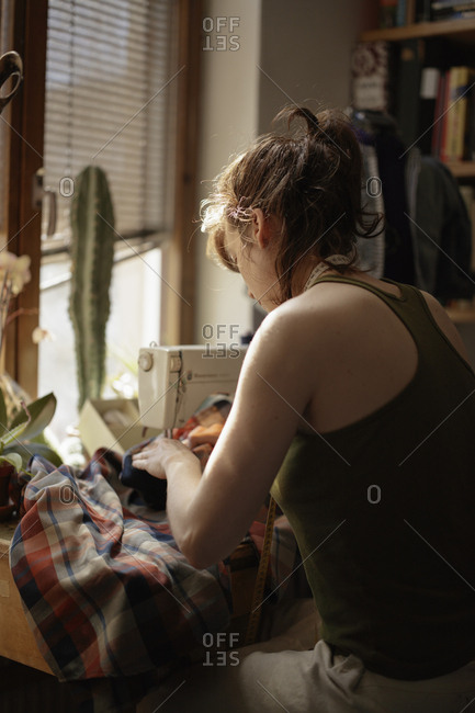 Sweden, Skane, Lund, mid adult woman working on sewing machine