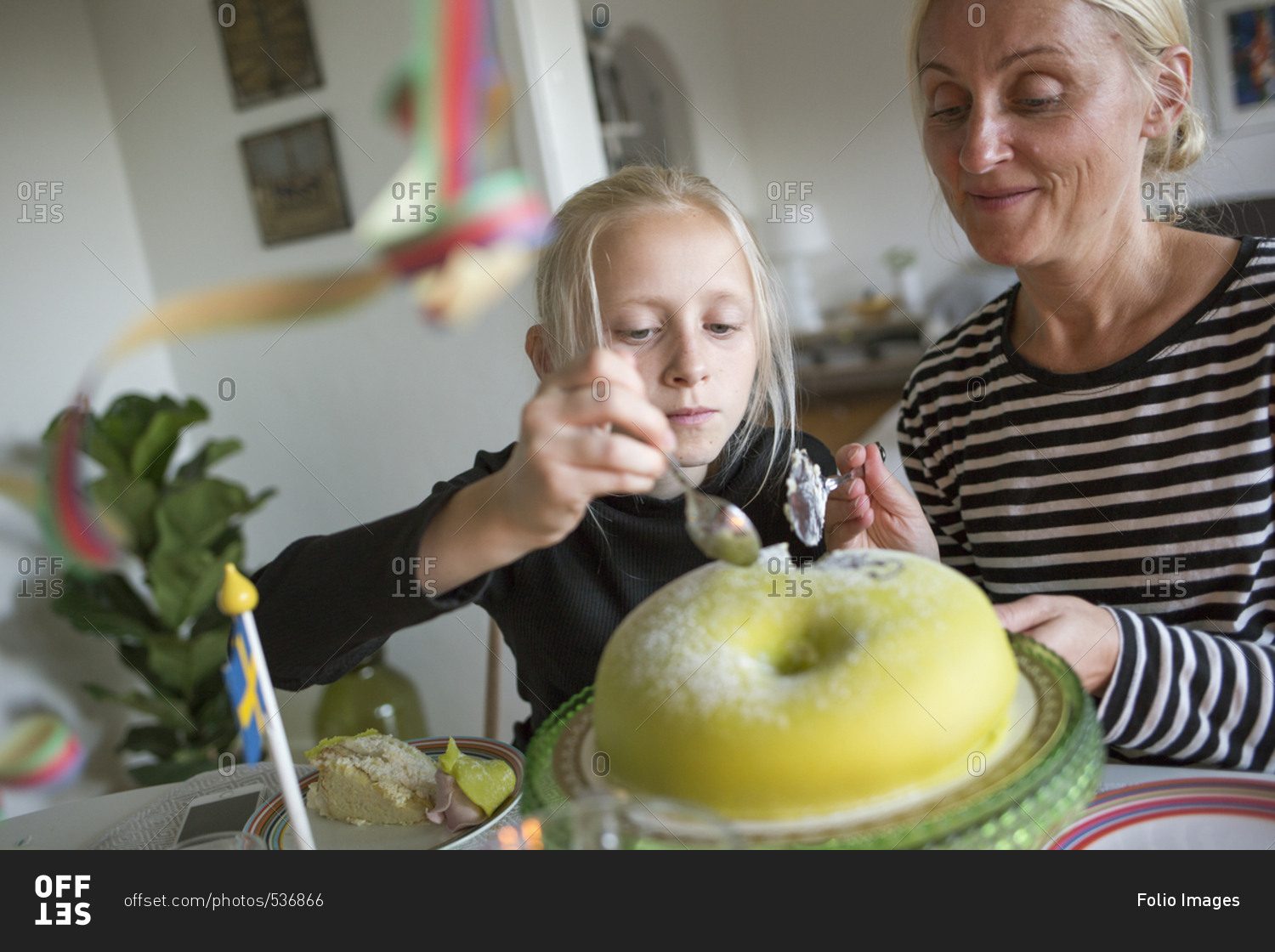 Sweden, Girl and mature woman cutting birthday cake