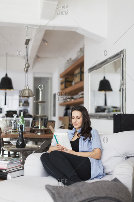 Germany, Woman reading in living room