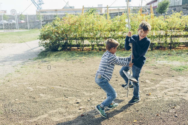 Sweden, Blekinge, Karlskrona, Boys playing with rope swing