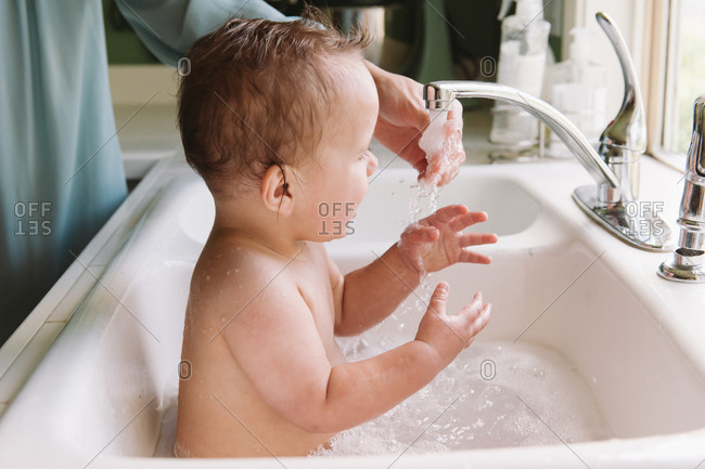 Mom Bathing Baby In The Kitchen Sink Stock Photo Offset
