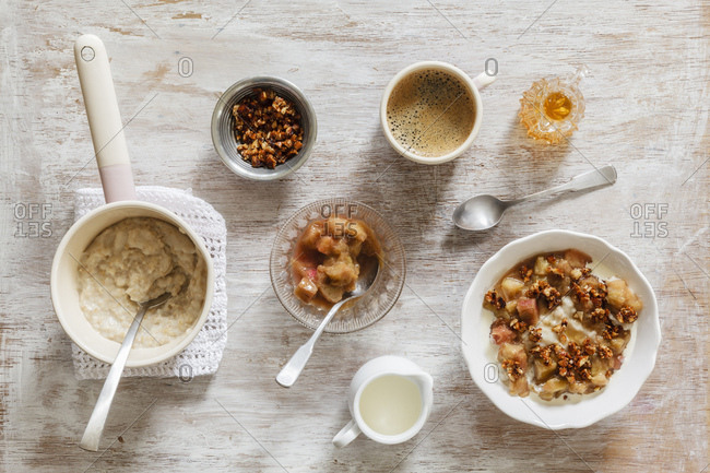 Breakfast with bowl of porridge with rhubarb compote - honey and nuts and cup of coffee