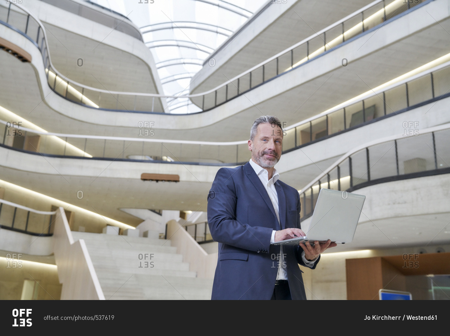 Businessman using laptop in modern office building