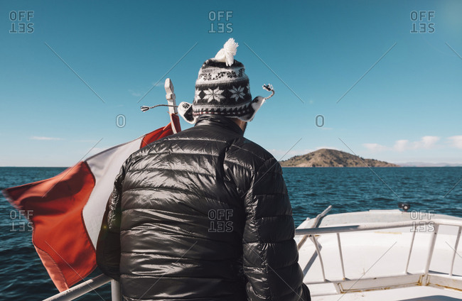 Peru - Titicaca lake - Taquile - man on a boat with Peruvian flag
